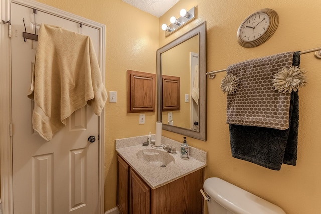 half bathroom featuring vanity and toilet