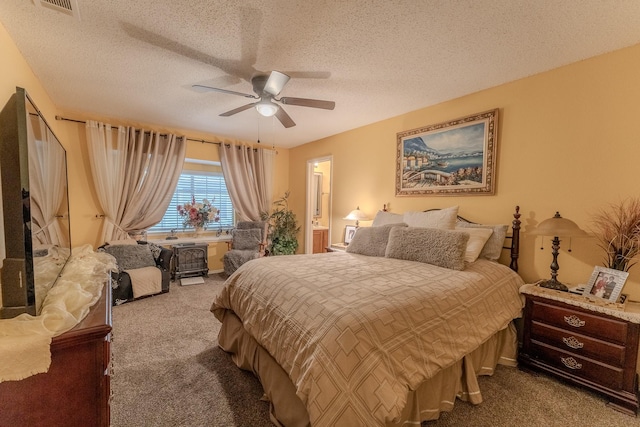 bedroom with visible vents, ceiling fan, ensuite bathroom, a textured ceiling, and dark colored carpet