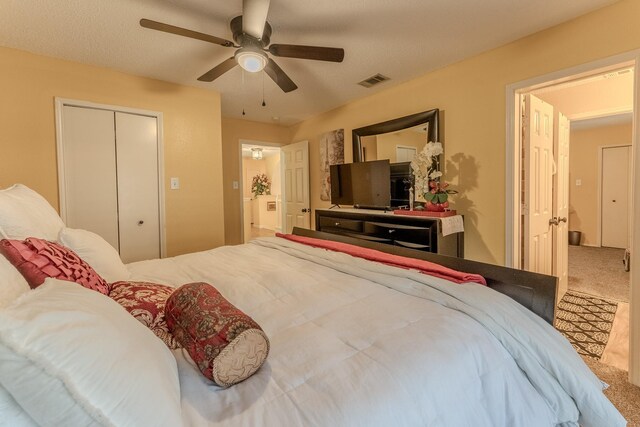 bedroom with carpet flooring, a ceiling fan, visible vents, and a closet