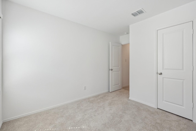 unfurnished bedroom featuring carpet, visible vents, and baseboards