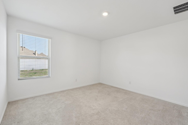 carpeted empty room featuring visible vents and baseboards