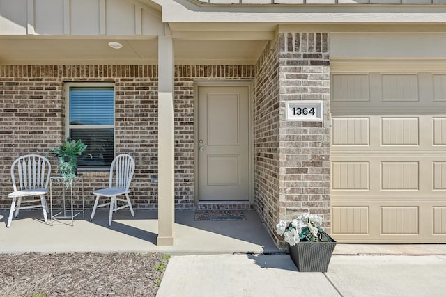 property entrance with board and batten siding and brick siding