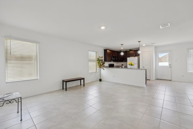 living room featuring recessed lighting, light tile patterned flooring, a healthy amount of sunlight, and visible vents