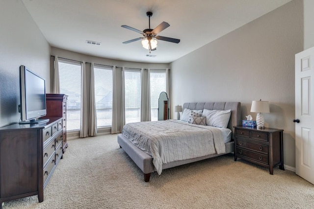 bedroom with light carpet, visible vents, and a ceiling fan