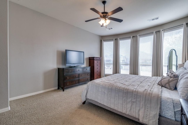 bedroom with multiple windows, light colored carpet, visible vents, and baseboards