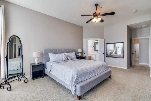 carpeted bedroom featuring ceiling fan, visible vents, baseboards, and connected bathroom