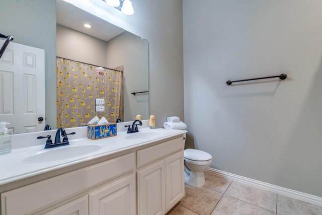 bathroom featuring a sink, toilet, double vanity, and tile patterned floors