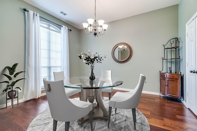 dining area featuring visible vents, baseboards, a notable chandelier, and dark wood-style flooring