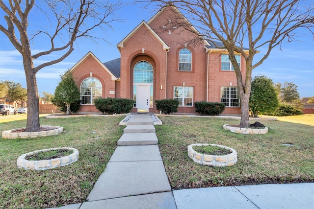 view of front of home featuring a front lawn and brick siding