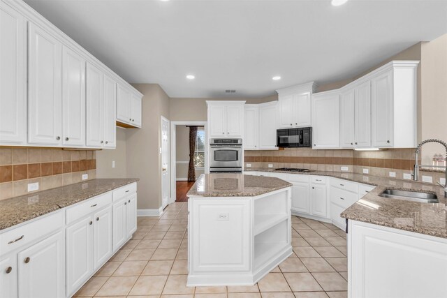 kitchen featuring a sink, light tile patterned floors, appliances with stainless steel finishes, white cabinets, and open shelves