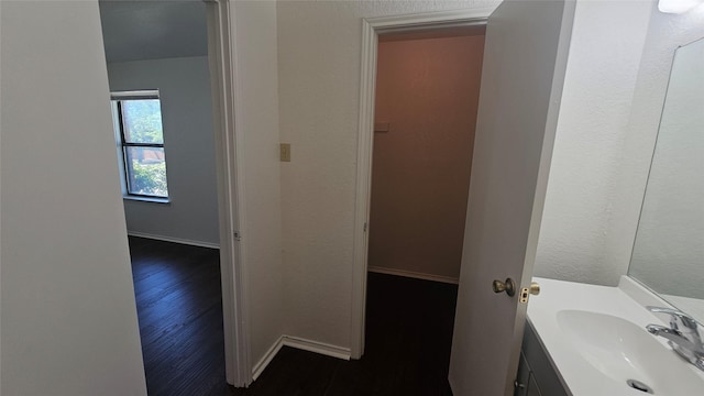 bathroom featuring vanity, baseboards, and wood finished floors