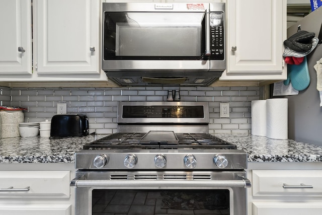 kitchen with decorative backsplash, appliances with stainless steel finishes, and white cabinets