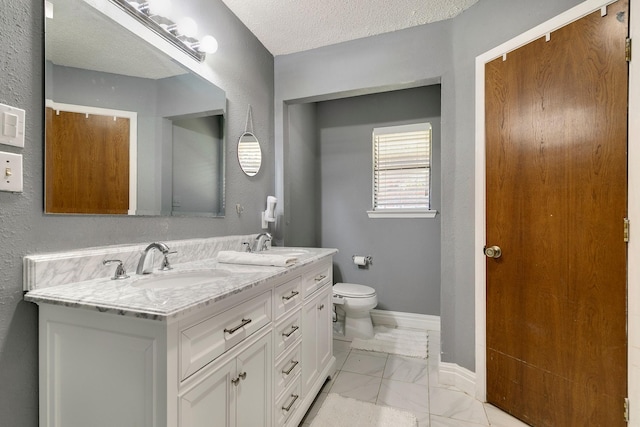 full bathroom featuring toilet, marble finish floor, a sink, a textured ceiling, and baseboards