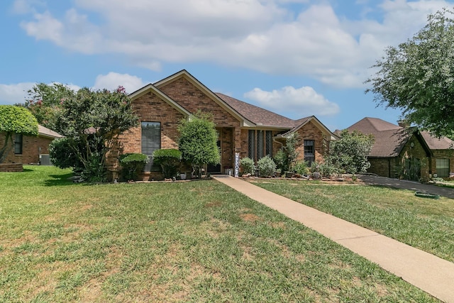 ranch-style house with a front yard and brick siding