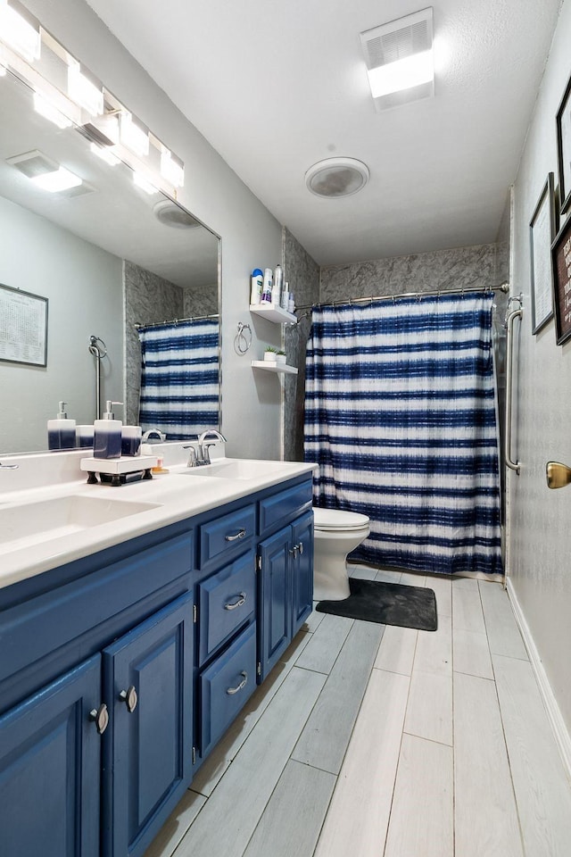 full bath featuring double vanity, toilet, visible vents, and a sink