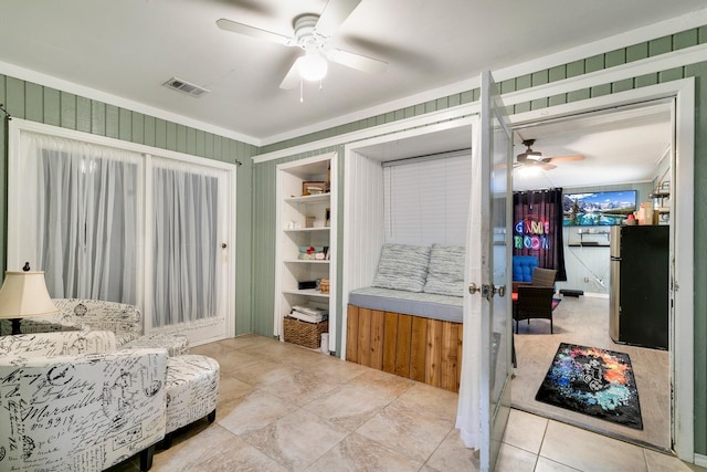 sitting room with visible vents and a ceiling fan