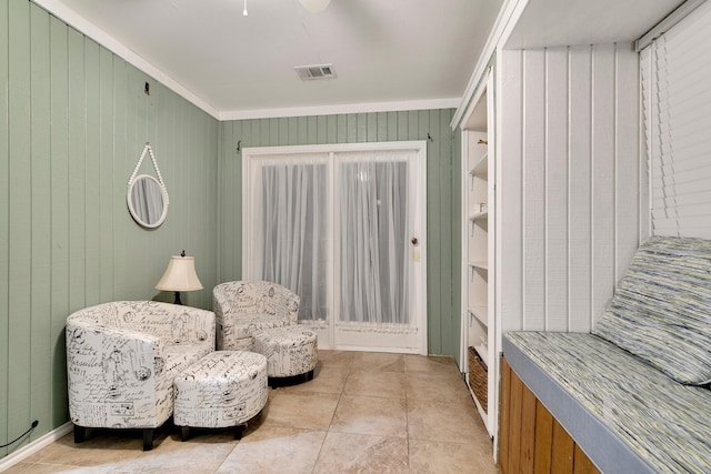 sitting room with light tile patterned flooring, visible vents, and crown molding