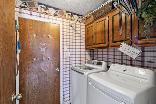 clothes washing area featuring cabinet space, a textured ceiling, wallpapered walls, and separate washer and dryer