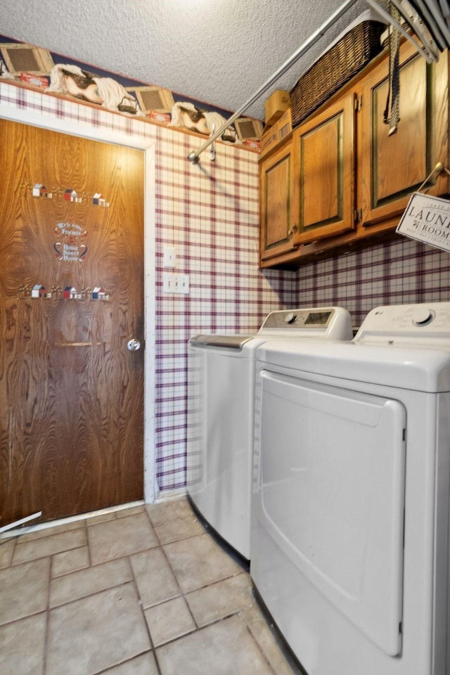 clothes washing area featuring cabinet space, a textured ceiling, independent washer and dryer, and wallpapered walls