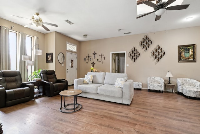 living area featuring wood finished floors, visible vents, and ceiling fan