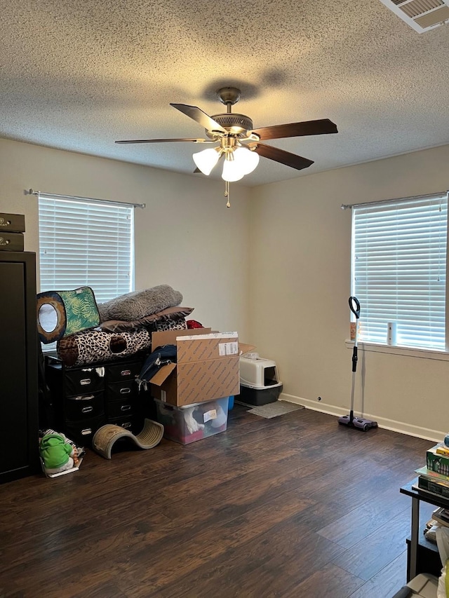 interior space with dark wood finished floors, baseboards, visible vents, and a textured ceiling