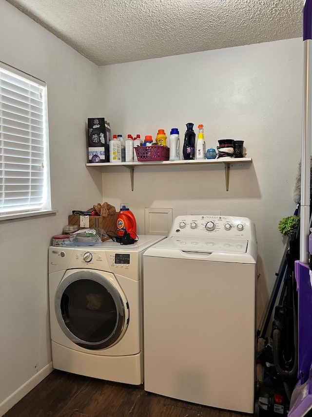 laundry room featuring a textured ceiling, dark wood finished floors, separate washer and dryer, baseboards, and laundry area