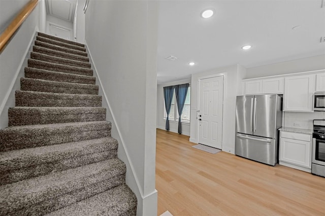 stairway featuring recessed lighting, baseboards, and wood finished floors