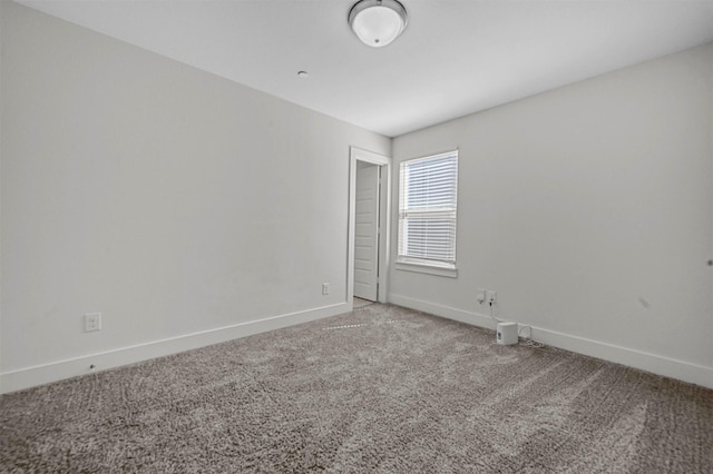 unfurnished room featuring carpet flooring and baseboards