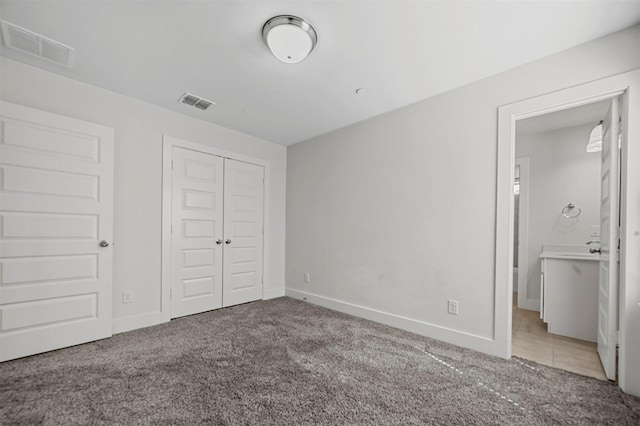 unfurnished bedroom with carpet flooring, baseboards, visible vents, and a closet