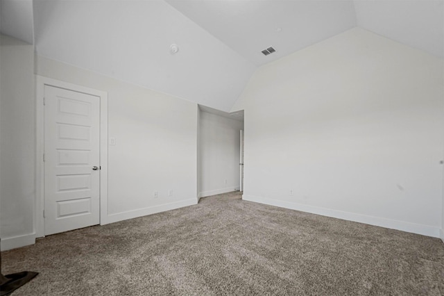 carpeted empty room featuring visible vents, baseboards, and vaulted ceiling