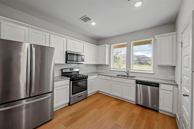 kitchen with light wood-style floors, visible vents, appliances with stainless steel finishes, and a sink