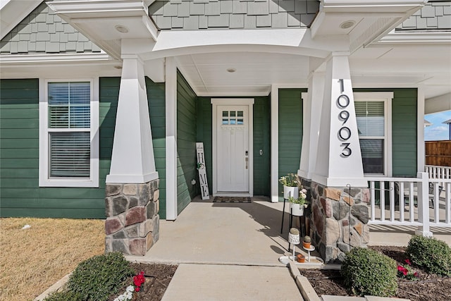 property entrance with covered porch and stone siding