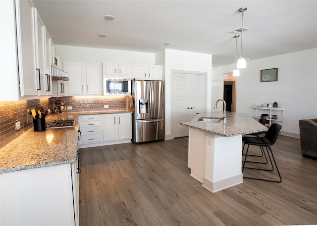 kitchen featuring a sink, white cabinets, tasteful backsplash, and stainless steel appliances