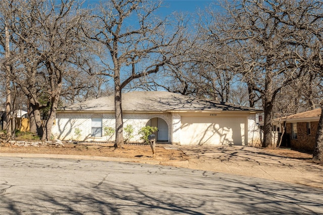 view of front facade with brick siding, an attached garage, and concrete driveway