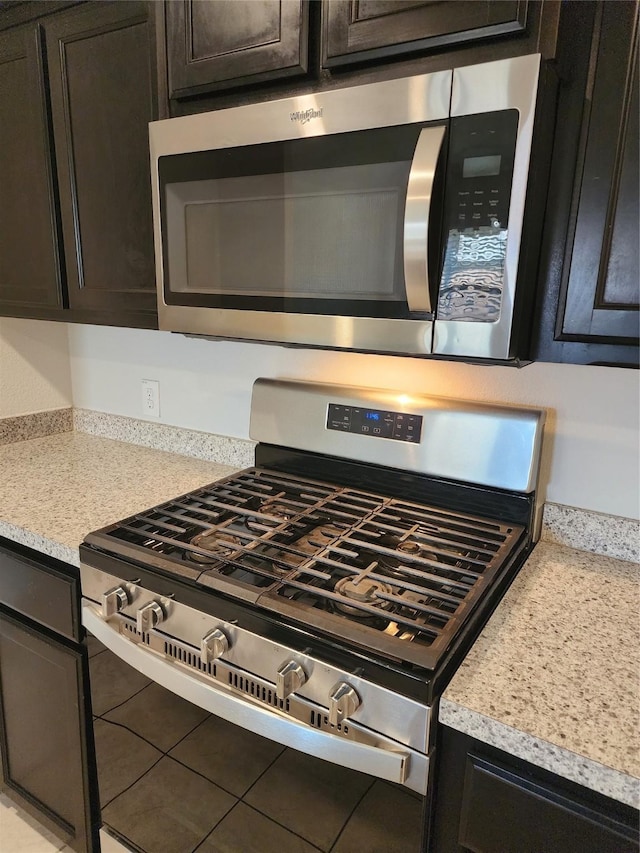 room details featuring stainless steel appliances, dark brown cabinetry, and light countertops