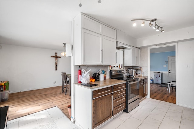 kitchen featuring under cabinet range hood, light countertops, light wood-style flooring, electric stove, and white cabinetry