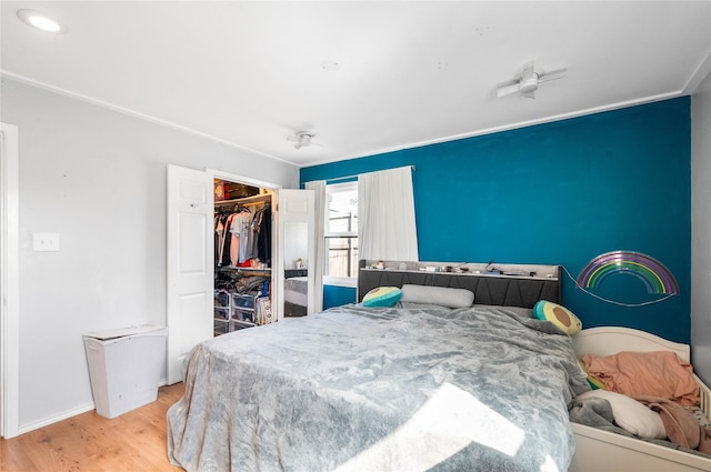 bedroom with a closet, baseboards, and wood finished floors