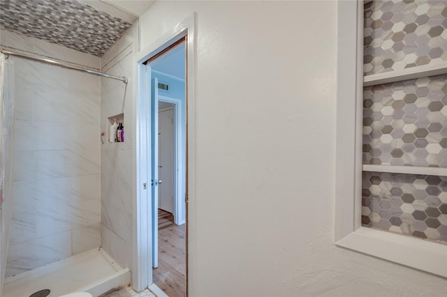 bathroom featuring wood finished floors and a stall shower