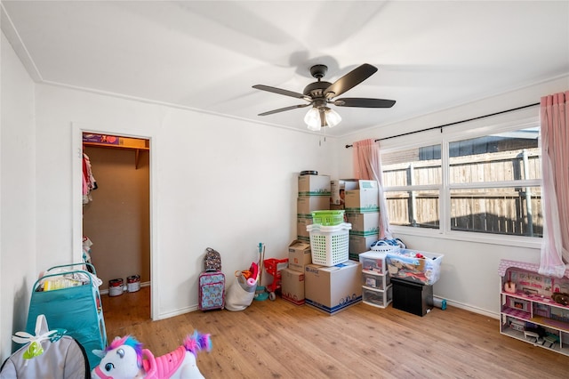 playroom with wood finished floors, baseboards, and ceiling fan