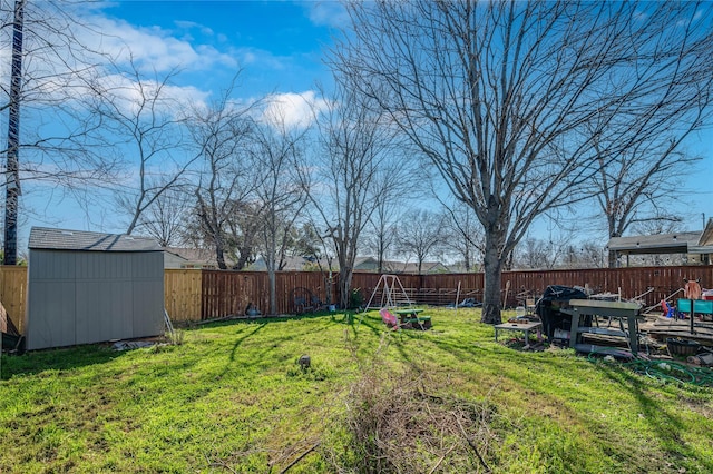 view of yard with a storage shed, an outbuilding, and a fenced backyard