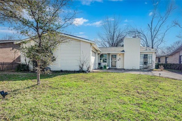 view of front of property with an attached garage, a chimney, a front lawn, and fence