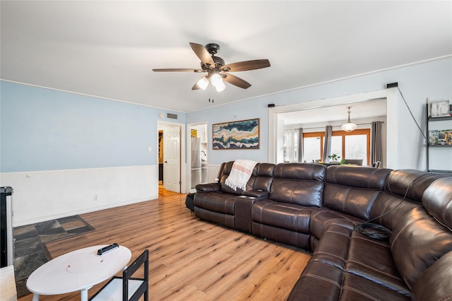 living area with visible vents, light wood-style flooring, and a ceiling fan