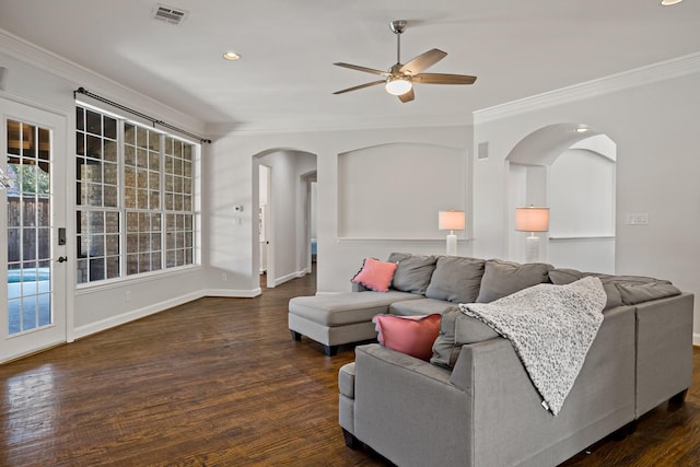 living area featuring dark wood finished floors, visible vents, and ornamental molding