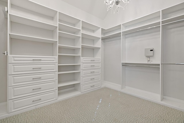 walk in closet featuring a notable chandelier