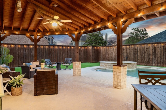 patio terrace at dusk featuring ceiling fan, a fenced in pool, an in ground hot tub, and a fenced backyard