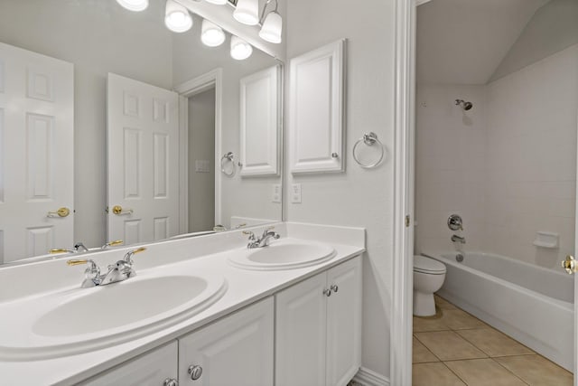 bathroom with tile patterned floors, double vanity, toilet, and a sink