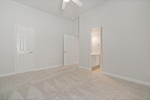 unfurnished bedroom with baseboards, light carpet, connected bathroom, and a ceiling fan