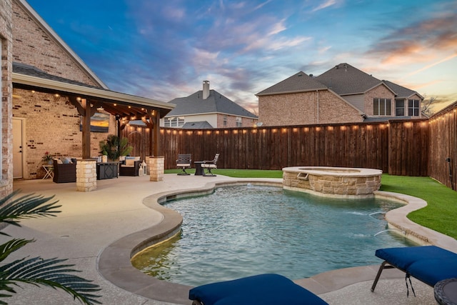 pool at dusk with a patio area, a jacuzzi, a fenced backyard, and a fenced in pool