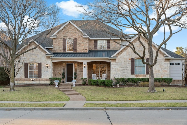 view of front of property featuring a standing seam roof, a porch, a front yard, a shingled roof, and metal roof