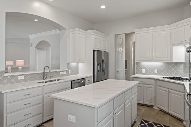 kitchen with a kitchen island, white cabinets, stainless steel appliances, and a sink